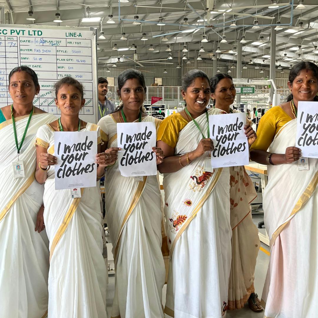 Employees at Sustainable Crafted Clothing, holding the #imadeyourclothes poster